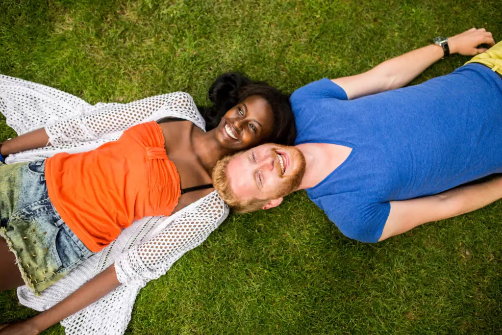 Multiracial couple laying on grass interracial dating central app download